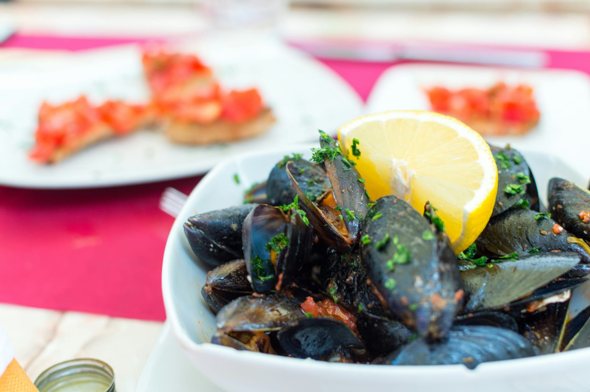 Healthy muscles prepared in a tomato broth topped with chives and lemon