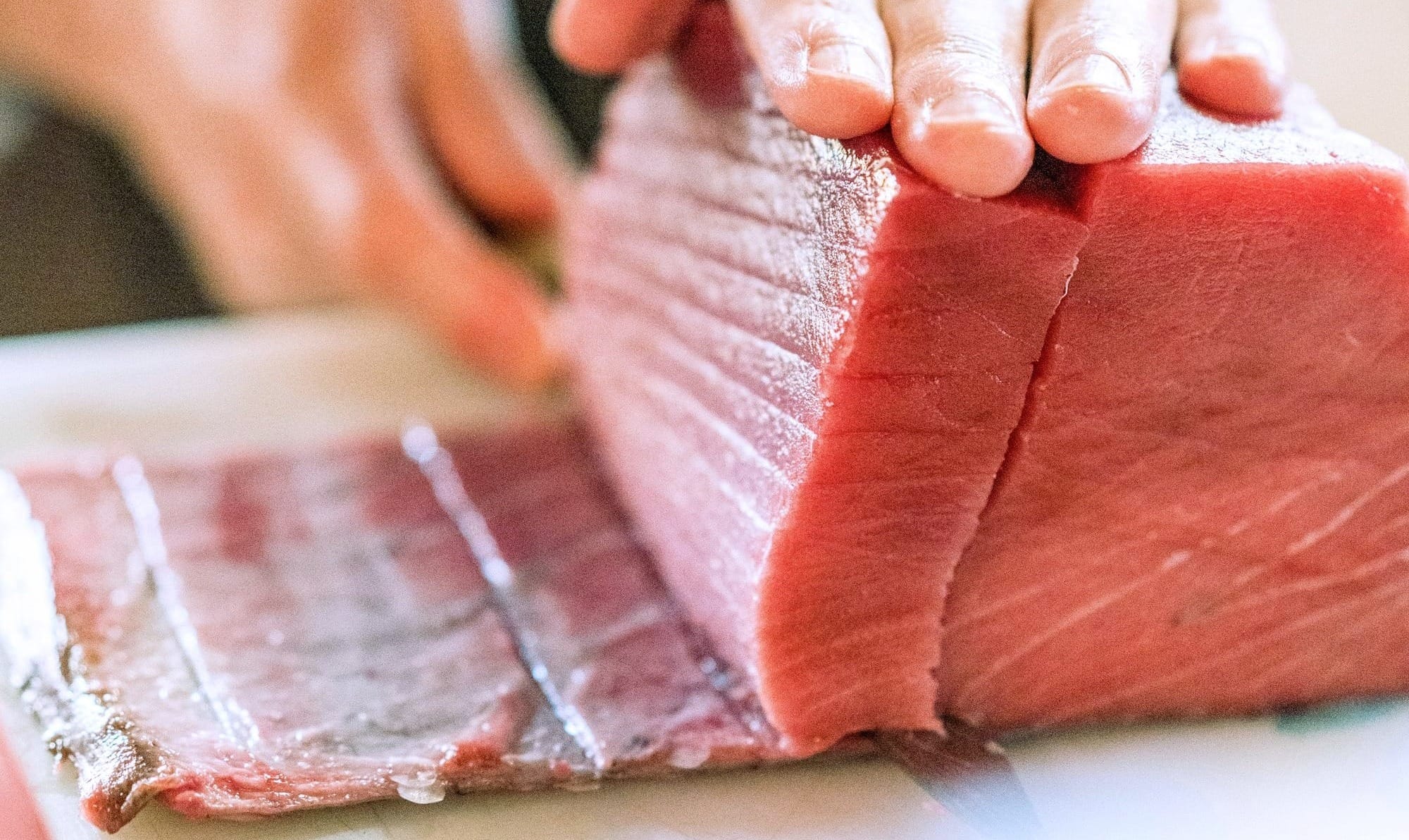 a person cutting raw tuna