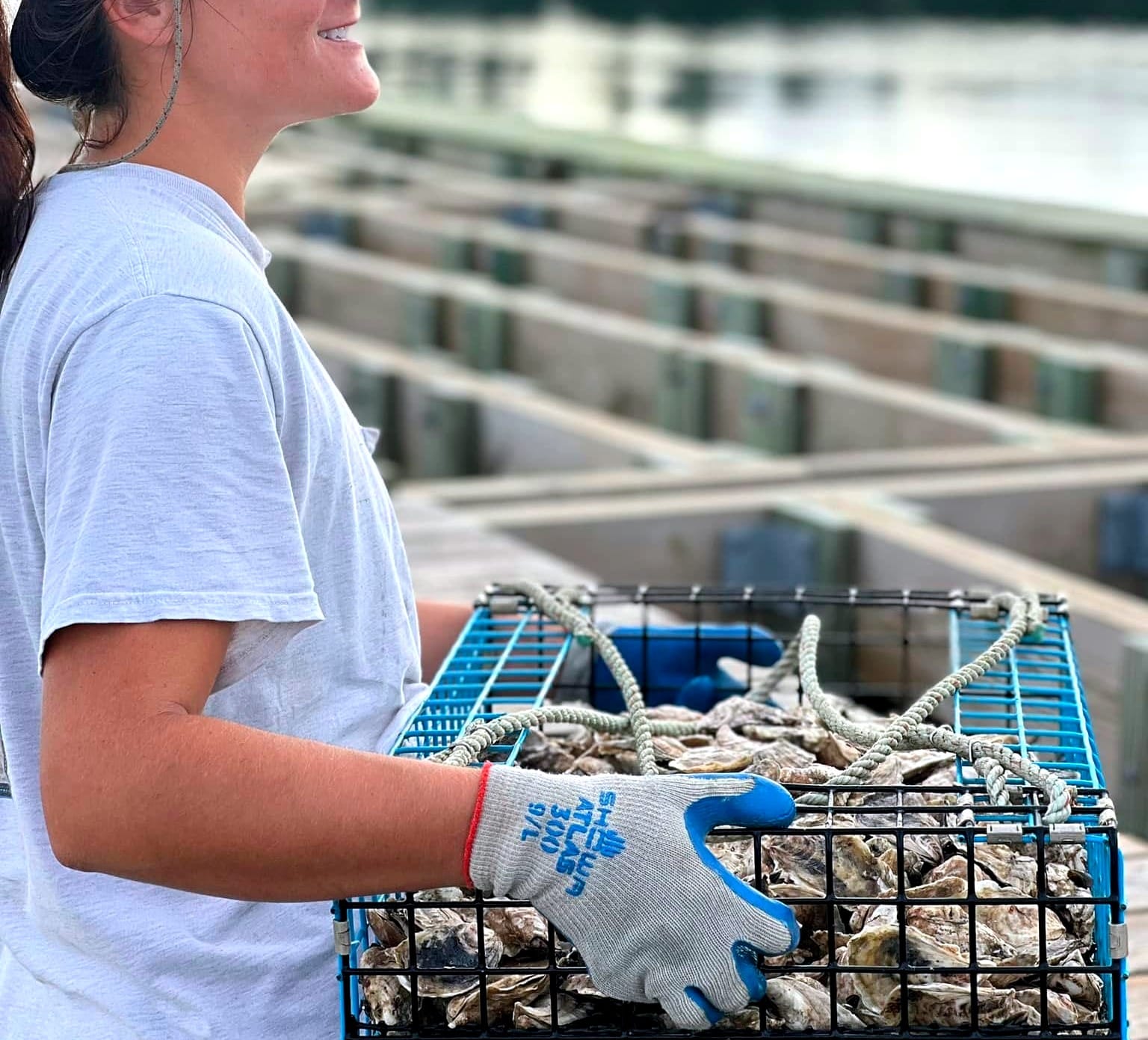 Seafood farmer carrying a basket of oysters