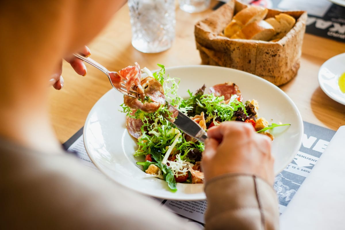 Woman eating a meal containing salmon omega 3 fatty acids